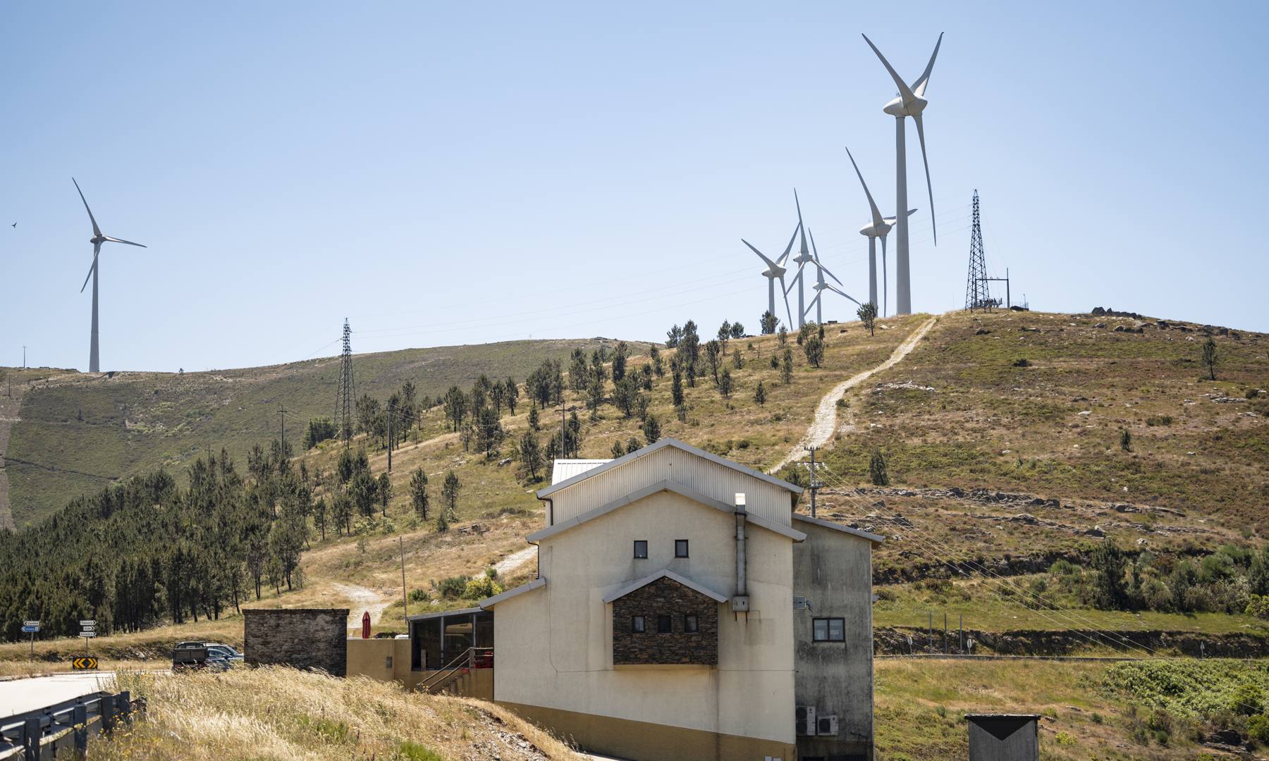 Wind turbines and transmission pylons above a village in Castelo Branco